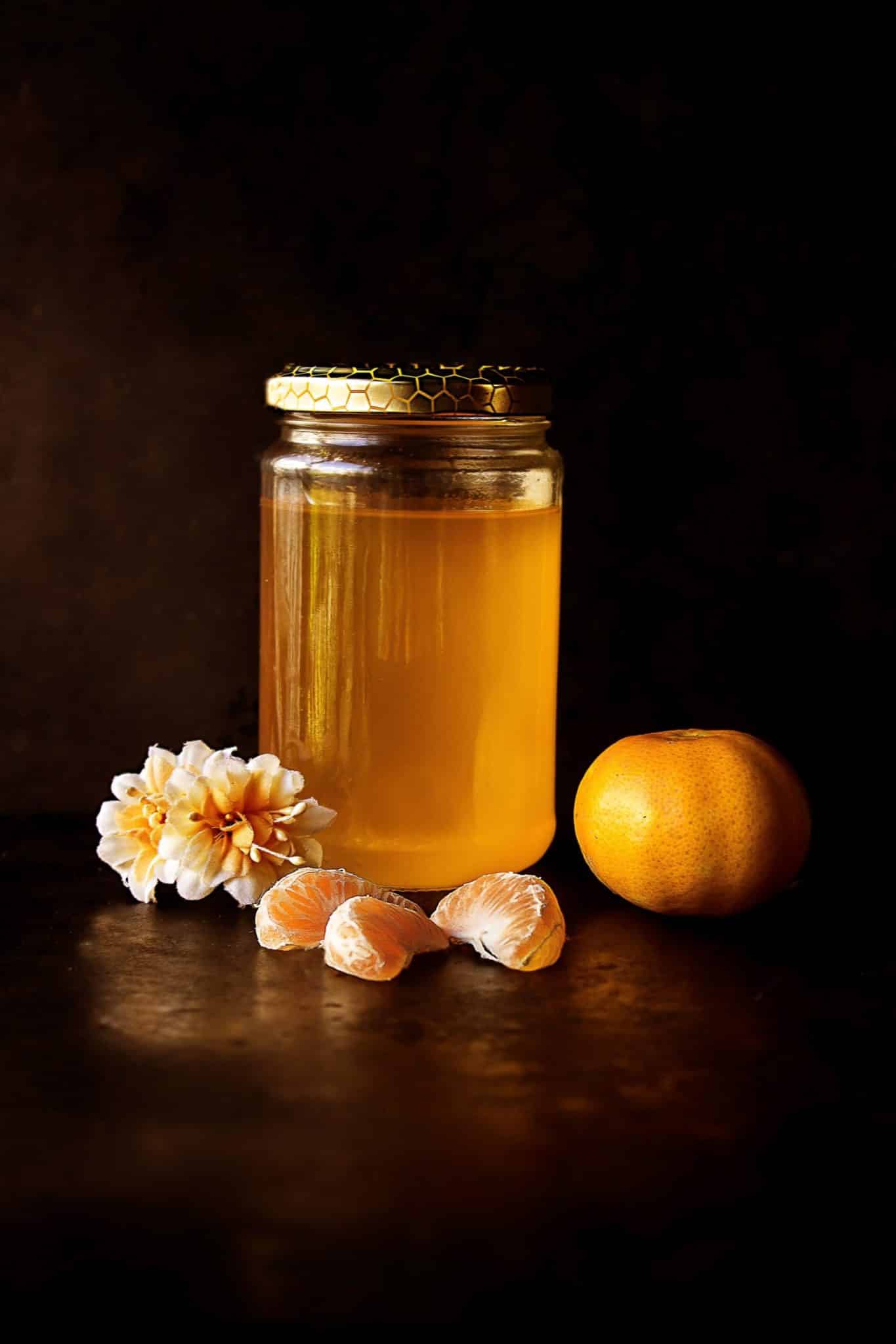 Honey in a jar, clementine, and a flower