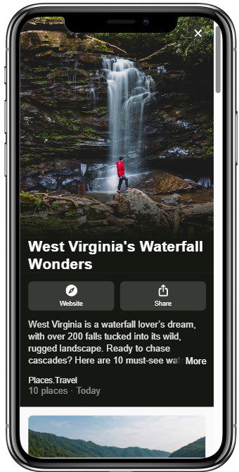 A person in a red jacket stands on rocks near the base of a tall, flowing waterfall surrounded by lush greenery in West Virginia.
