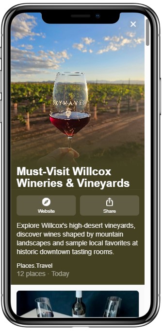 Smartphone screen displaying a travel guide titled “Must-Visit Willcox Wineries & Vineyards” featuring a photo of a wine glass held up against a vineyard at sunset.